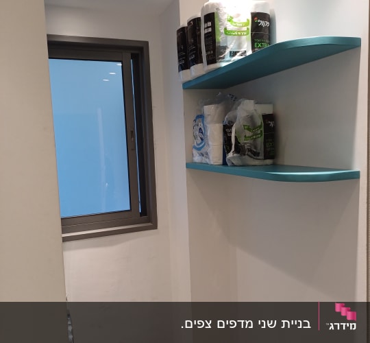 מדפים כחולים מותקנים על קיר לבן